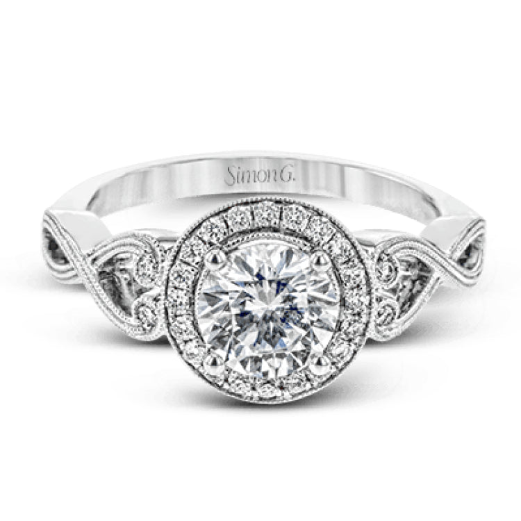This remarkably beautiful white gold ring features intricate milgrain details alongside a lovely halo of .06 ctw of round white diamonds.