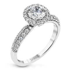 This delicate, vintage-inspired engagement ring sparkles with .42 ctw of round white diamonds in its halo and side details, all set in beautiful white gold.