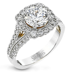 This engagement ring has a unique design with a halo of bezel set diamonds. The setting contains .81 ctw of white diamonds.