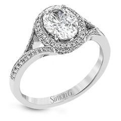 Elegant and sophisticated, this white gold ring's delicate halo and split shank glitter with .28 ctw of round white diamonds to highlight an oval shaped center stone.