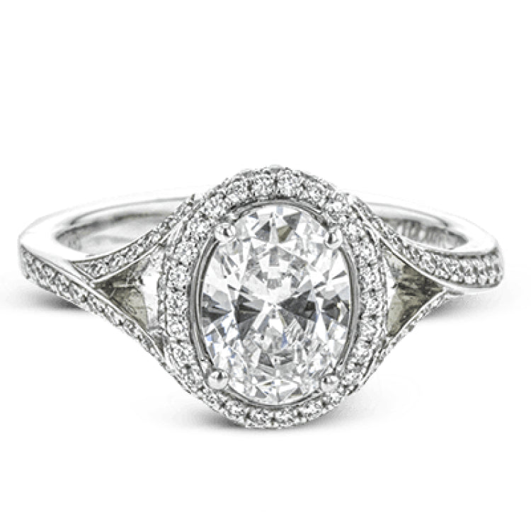 Elegant and sophisticated, this white gold ring's delicate halo and split shank glitter with .28 ctw of round white diamonds to highlight an oval shaped center stone.