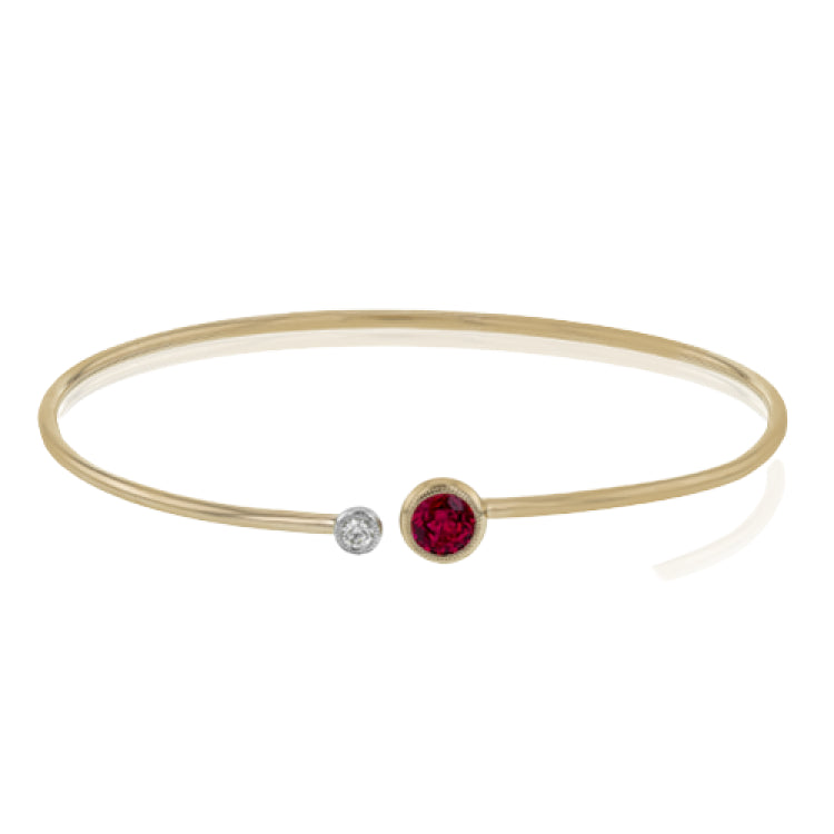 This understated rose gold bangle features a subtle .08 ctw white diamond accent opposite a stunning .73 ctw ruby. Perfect for stacking.