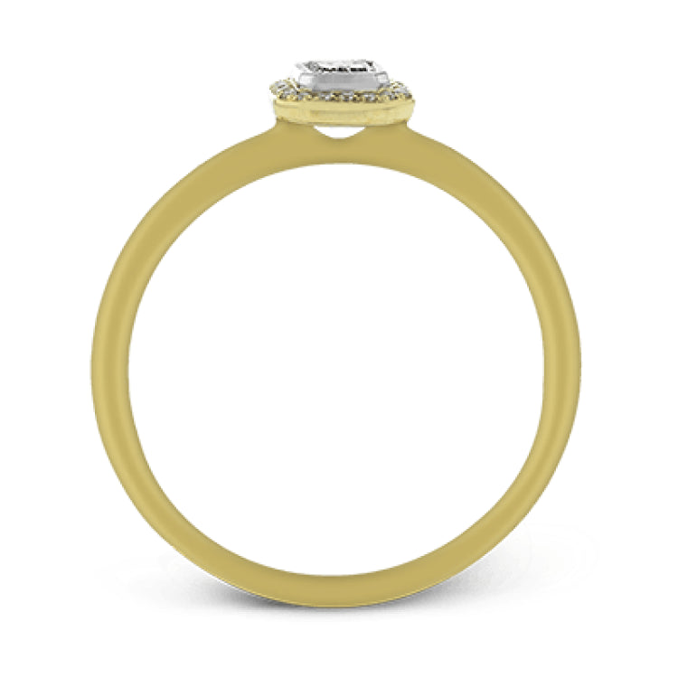This exquisite, minimalist yellow gold ring features a halo containing .04 ctw of round white diamonds encircling a .16 ctw emerald cut white diamond