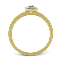 This exquisite, minimalist yellow gold ring features a halo containing .04 ctw of round white diamonds encircling a .16 ctw emerald cut white diamond