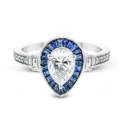 This beautiful pear-shaped setting displays .82 ctw of baguette sapphires in a halo around the center stone. The rest of the ring sparkles with .11 ctw of round diamonds and .17 ctw of baguette diamonds.