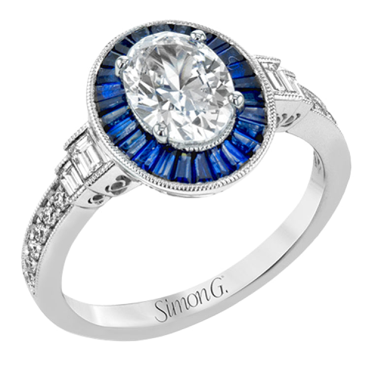 This remarkable ring features milgrain edging and .75 ctw of baguette shaped sapphires in its halo, flanked by .11 ctw of round white diamonds and .16 ctw of baguette shaped white diamonds.