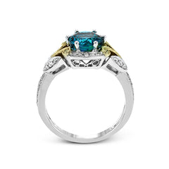 This two-toned vintage inspired right hand ring features a blue zircon center 3.11 ctw. surrounded by white diamonds 0.25 ctw and accented by natural yellow diamonds set in a yellow gold filigree detail.