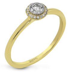 This exquisite, minimalist yellow gold ring features a halo containing .04 ctw of round white diamonds encircling a .16 ctw round white diamond centerpiece