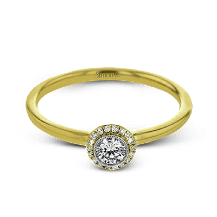 This exquisite, minimalist yellow gold ring features a halo containing .04 ctw of round white diamonds encircling a .16 ctw round white diamond centerpiece