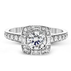This sleek, contemporary white gold engagement ring contains .35 ctw of round white diamonds and .19 ctw of baguette shaped diamonds on its shank and unique, geometric halo