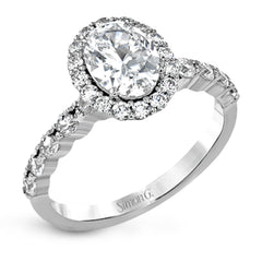 This white gold ring's clean, modern design features a halo and shank that dazzle with .70 ctw of round white diamonds.