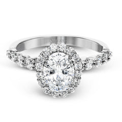 This white gold ring's clean, modern design features a halo and shank that dazzle with .70 ctw of round white diamonds.