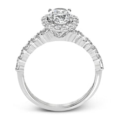 This white gold ring's clean, modern design features a halo and shank that dazzle with .70 ctw of round white diamonds.