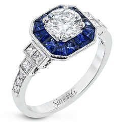 This 18k white gold engagement setting would be a perfect 'something blue' with .79 ctw of baguette sapphires in a halo surrounding the center stone. These are framed by .33 ctw of princess cut diamonds and .11 ctw of round brilliant diamonds.