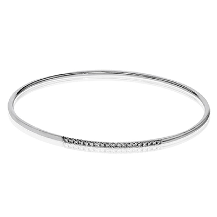 This lovely 18k white gold bangle contains .13 ctw of white diamonds in a simple line. This bangle is perfect for stacking, or making a delicate statement all on its own.