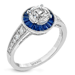 This 18k white gold engagement ring add something special with .56 ctw of baguette sapphires in a halo around the center stone. A total of .36 ctw of white diamonds finish this remarkable design.
