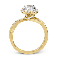 This sparkling modern engagement ring features an eye-catching twisted design with elegant classic halo accented by .29 ctw of shimmering round cut white diamonds.