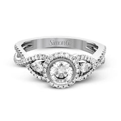 This 18k white gold wedding set has a distinctive design with a milgrain accented bezel center stone setting, .15 ctw pear side stones, and .50 ctw of round brilliant diamonds.