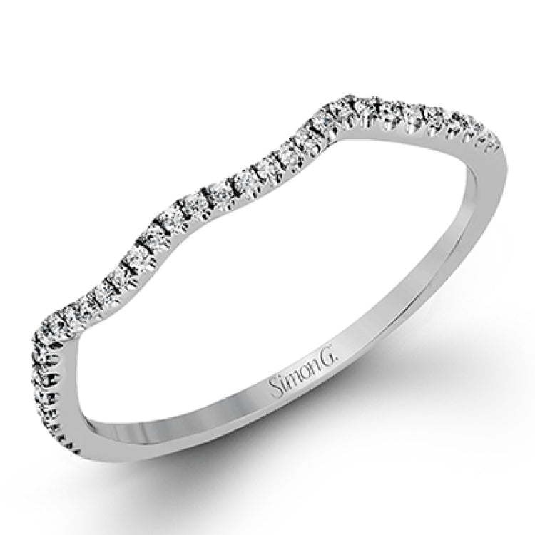 This 18k white gold wedding set has a distinctive design with a milgrain accented bezel center stone setting, .15 ctw pear side stones, and .50 ctw of round brilliant diamonds.