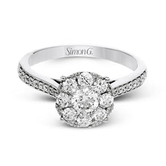 This delightful ring is crafted from 18k white gold and features a .30 ct white diamond in the center of .50 ctw of smaller round white diamonds.