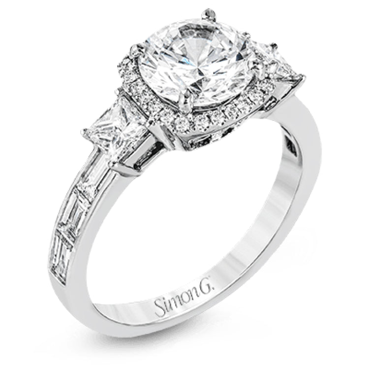 The impressive circular halo of this white gold engagement ring is set with .10 ctw round cut white diamonds and emphasized by .43 ctw princess cut diamonds and .58 baguette cut diamonds.
