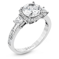 The impressive circular halo of this white gold engagement ring is set with .10 ctw round cut white diamonds and emphasized by .43 ctw princess cut diamonds and .58 baguette cut diamonds.