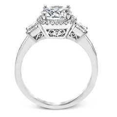 The impressive circular halo of this white gold engagement ring is set with .10 ctw round cut white diamonds and emphasized by .43 ctw princess cut diamonds and .58 baguette cut diamonds.