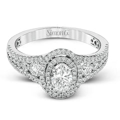 Featuring an exquisite contemporary design, this white gold engagement ring features an eye-catching oval double halo complemented by .68 ctw of round cut white diamonds.