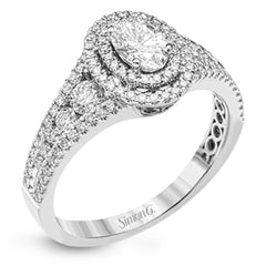 Featuring an exquisite contemporary design, this white gold engagement ring features an eye-catching oval double halo complemented by .68 ctw of round cut white diamonds.