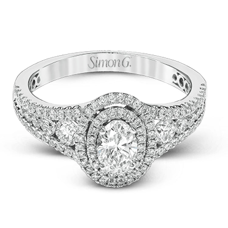 Featuring an exquisite contemporary design, this white gold engagement ring features an eye-catching oval double halo complemented by .68 ctw of round cut white diamonds.
