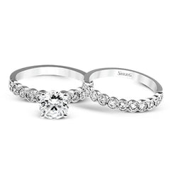 This engagement and wedding band set combines old and new with 1.09 ctw of round brilliant diamonds bezel set into 18k white gold, accented with vintage-inspired milgrain.
