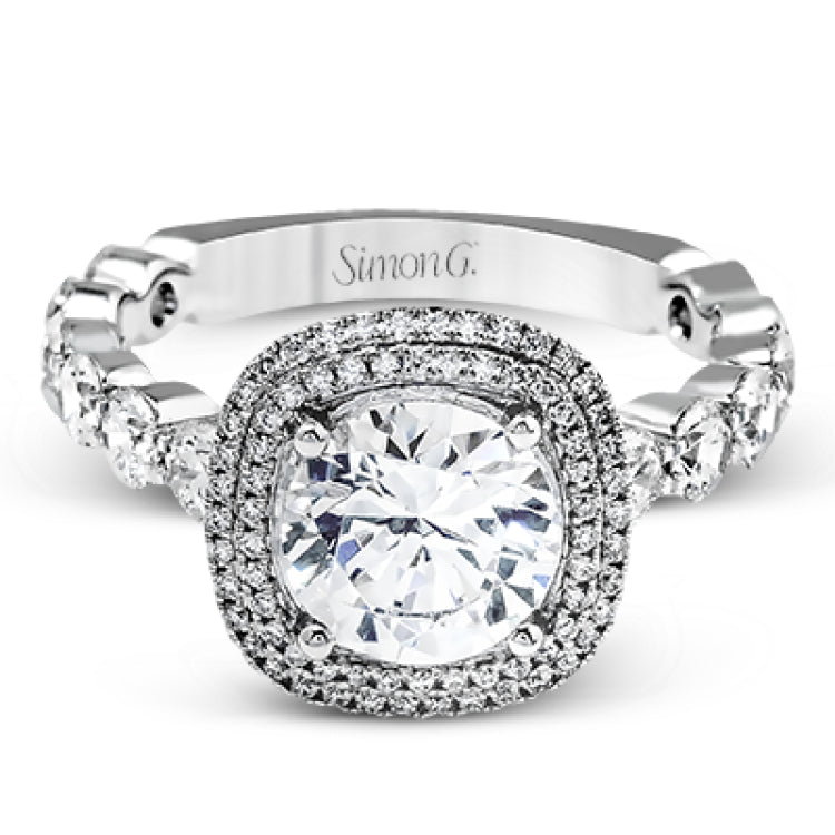 The delicate design of this classic white gold engagement ring features a sparkling pave halo accented with .86 ctw of shimmering round cut white diamonds.