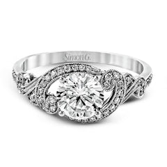This lovely modern white gold engagement ring features a memorable halo and is accentuated by .19 ctw glistening round cut white diamonds.