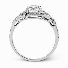 This lovely modern white gold engagement ring features a memorable halo and is accentuated by .19 ctw glistening round cut white diamonds.