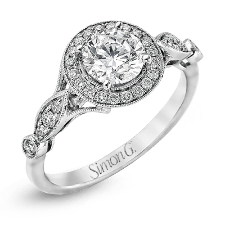 This sparkling white gold vintage inspired engagement ring features an exquisite halo and is set with .25 ctw round cut white diamonds.