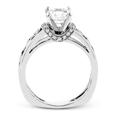 Set with delicate floral patterns, this classic white gold engagement ring is highlighted with .12 ctw round cut white diamonds.