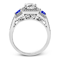 Featuring an elegant classic design, this white gold engagement ring is set with .23 ctw round cut white diamonds and side accents of .62 ctw trapezoid cut sapphires.