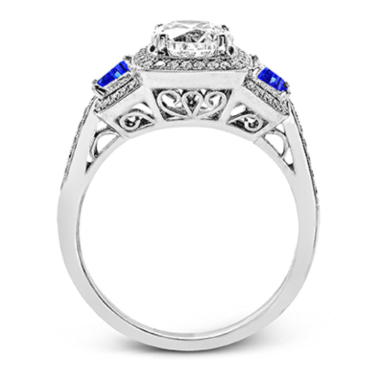 Featuring an elegant classic design, this white gold engagement ring is set with .23 ctw round cut white diamonds and side accents of .62 ctw trapezoid cut sapphires.