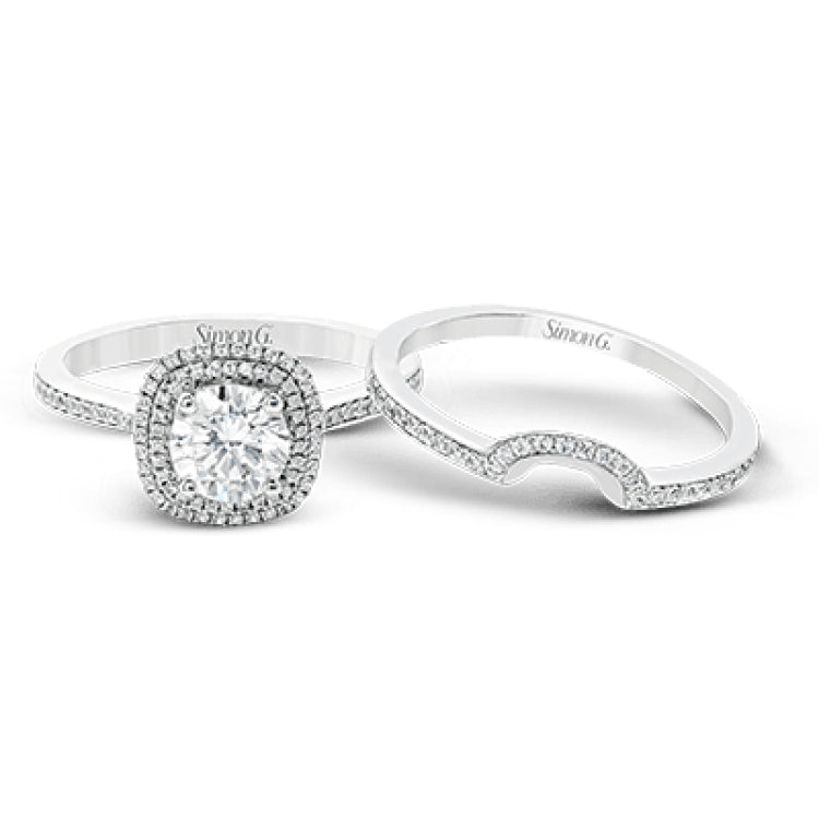 Classy and elegant, this contemporary white gold halo engagement ring and wedding band set is set with .34 ctw of round cut white diamonds.
