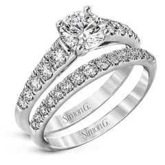 Elevating a classic design with modern elements, this exquisite white gold engagement ring and band are emphasized by .77 ctw of sparkling round cut white diamonds.