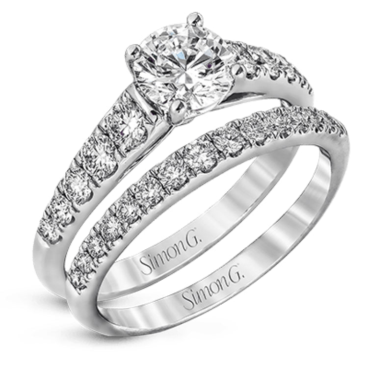 Elevating a classic design with modern elements, this exquisite white gold engagement ring and band are emphasized by .77 ctw of sparkling round cut white diamonds.