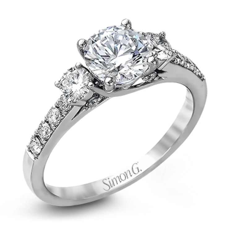 This classic three-stone engagement ring features .24 ctw of round brilliant side stones and .23 ctw of white diamonds extending down the sides.