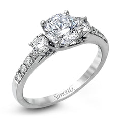 This classic three-stone engagement ring features .24 ctw of round brilliant side stones and .23 ctw of white diamonds extending down the sides.