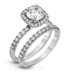 This elegant classic white gold halo engagement ring and band is set with .78 ctw of sparkling round cut white diamonds.