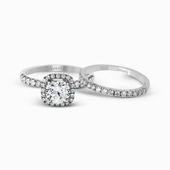 This elegant classic white gold halo engagement ring and band is set with .78 ctw of sparkling round cut white diamonds.