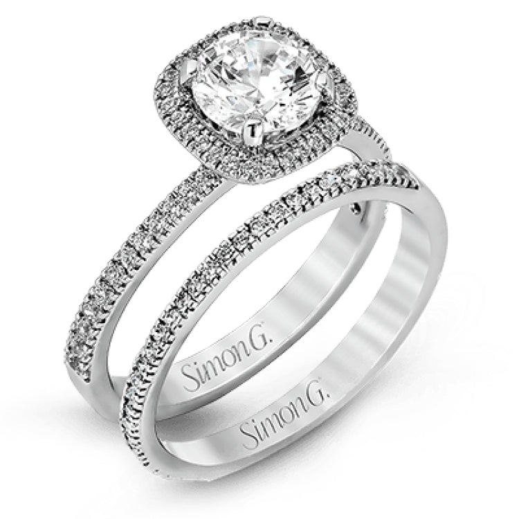 Accented by .46 ctw of glistening round cut white diamonds, this contemporary white gold halo style engagement ring and wedding band set makes a dramatic statement.
