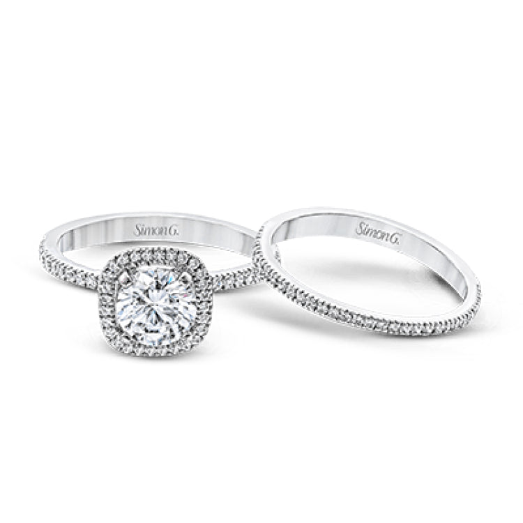 Accented by .46 ctw of glistening round cut white diamonds, this contemporary white gold halo style engagement ring and wedding band set makes a dramatic statement.
