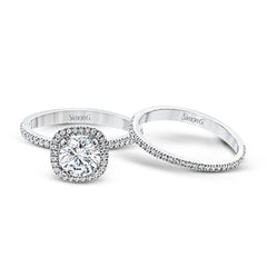 Accented by .46 ctw of glistening round cut white diamonds, this contemporary white gold halo style engagement ring and wedding band set makes a dramatic statement.