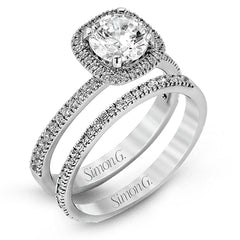 Accented by .46 ctw of glistening round cut white diamonds, this contemporary white gold halo style engagement ring and wedding band set makes a dramatic statement.