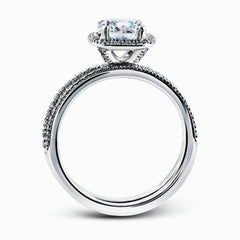 Accented by .46 ctw of glistening round cut white diamonds, this contemporary white gold halo style engagement ring and wedding band set makes a dramatic statement.